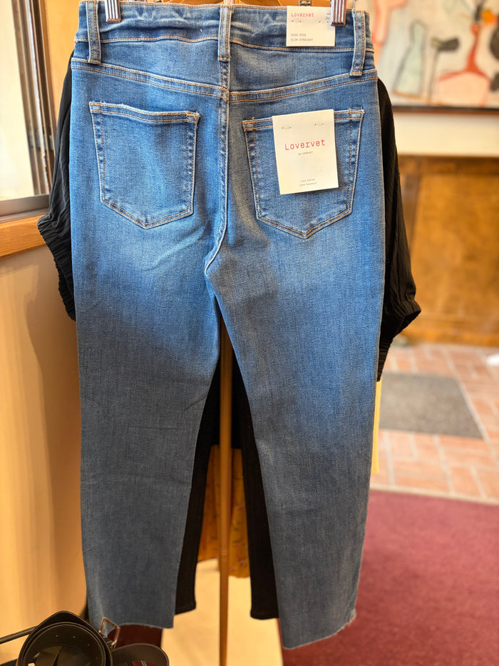 Vervet Masterfully Jean in classic blue denim, full-length jeans with a slim fit and five-pocket design, displayed on a hanger.
