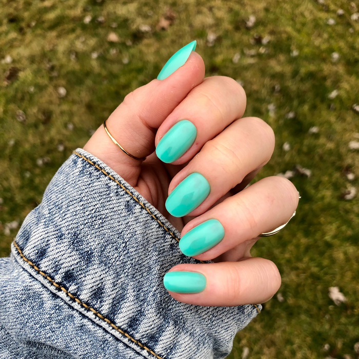 Fresh Aqua - Press-On | Short | Round showing hand wearing short round turquoise-green press-on nails outdoors on denim jacket sleeve