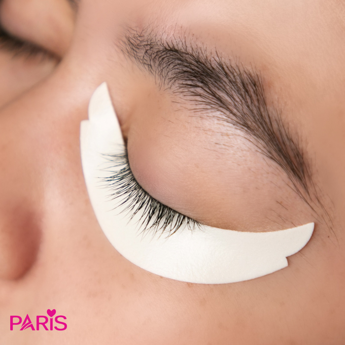 White foam eyepad on the bottom of a person's eye, brand 'PARIS' visible.