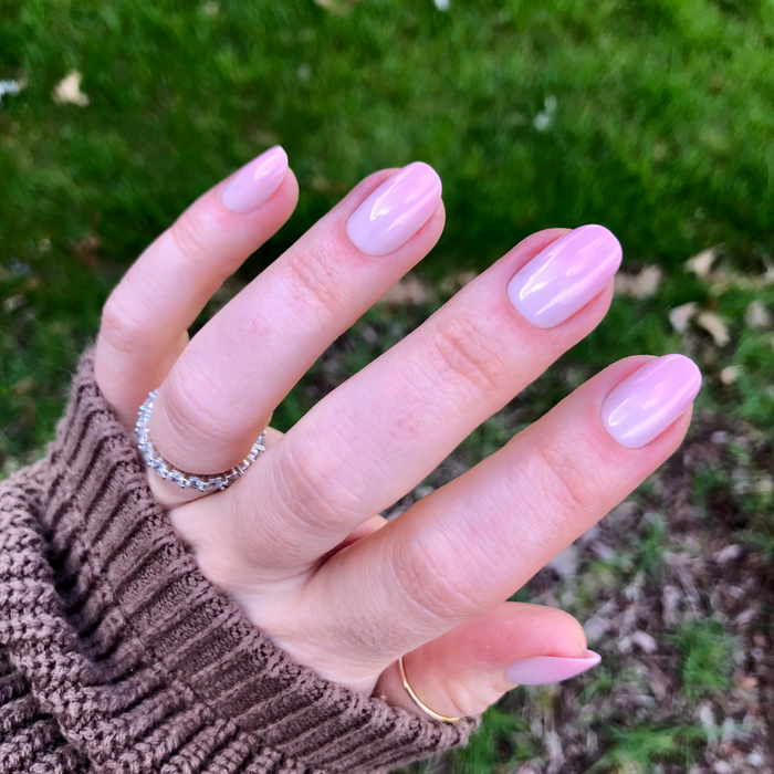 Rose Syrup Gradient - Press-On | Short | Round showing hand with short round false nails in soft rosy pink manicure outdoors