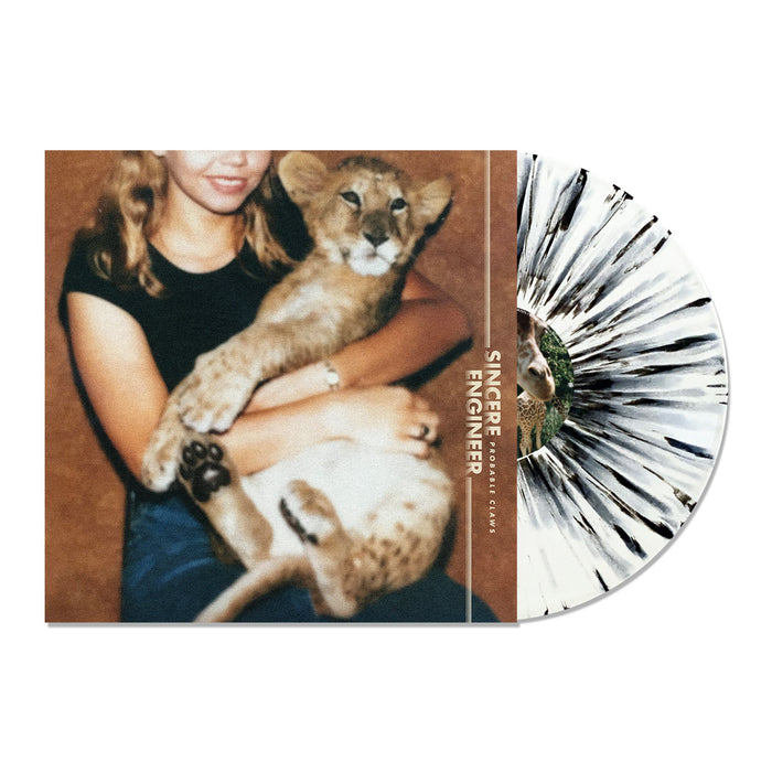 A limited edition black and white splatter vinyl by Sincere Engineer rests beside its cover, which shows a woman in a black shirt smiling with a lion cub and features exclusive "Sincere Engineer" text.
