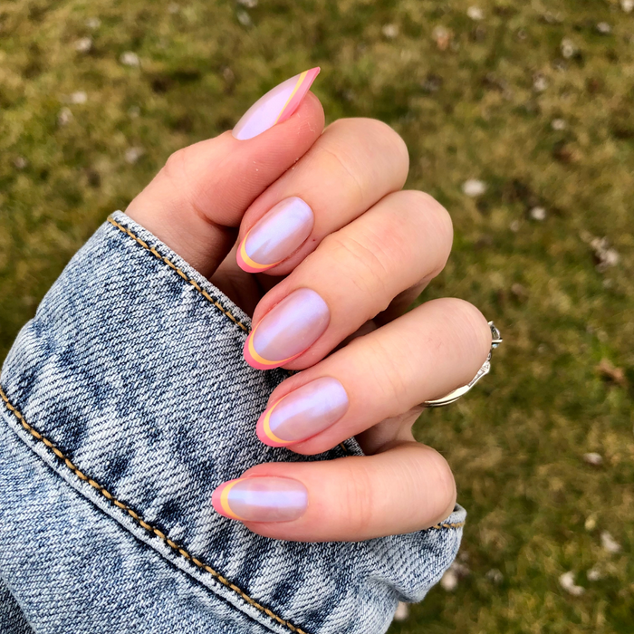 Sunset Double French - Press-On | Medium | Oval showing hand with medium oval iridescent nails and orange magenta double french tips outdoors