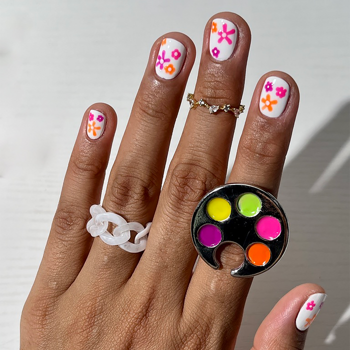 Vivid Era neon liners on a palette ring with floral nail art on a medium skin tone
