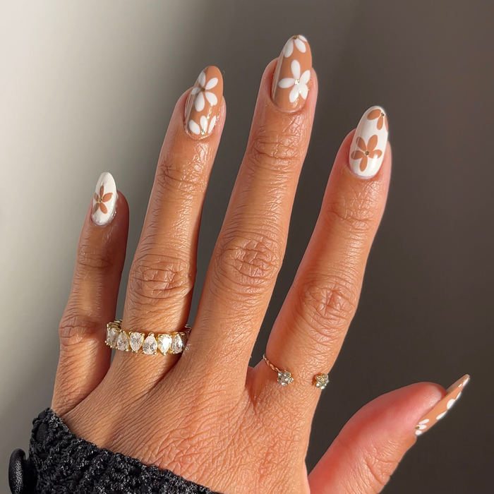 11th Hour mocha brown nail polish with white floral accent nail art and rings
