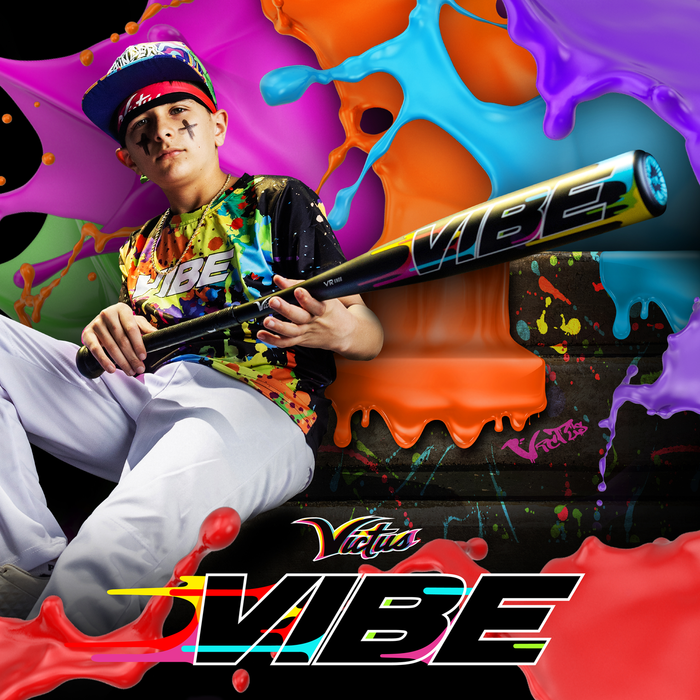 A young player in a colorful Vibe uniform and hat grips the 2024 Victus Vibe (-10) USSSA bat with vibration reducing knob, sitting confidently before a vibrant, paint-splashed backdrop featuring the Victus Vibe logo.