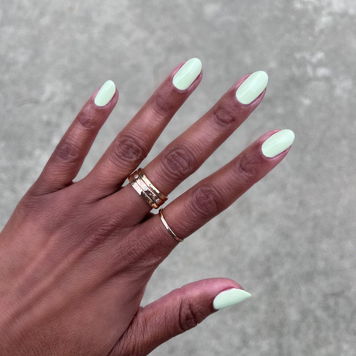 Corrigan mint pastel green polish on medium-length nails with a smooth finish for an easy at-home manicure