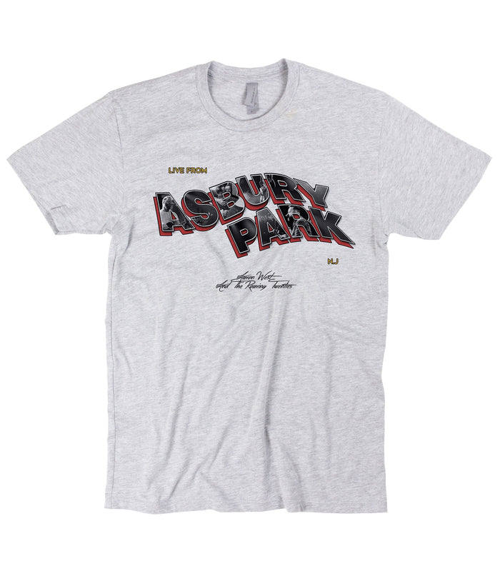 Grey t-shirt on a white background. Text reads "Live From Asbury Park" NJ. The Asbury Park portion is wavy 3D text. Aaron West And The Roaring Twenties in small centered black text below that.