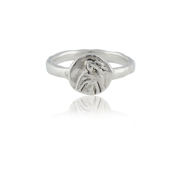 A silver ring featuring an intricately detailed depiction of a saint figure on its face.