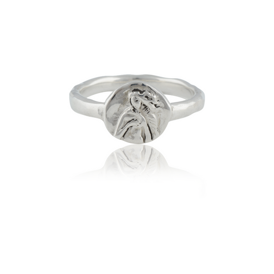 A silver ring featuring an intricately detailed depiction of a saint figure on its face.