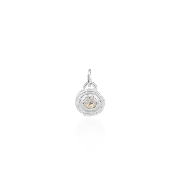 Silver pendant with a small round gemstone on a white background