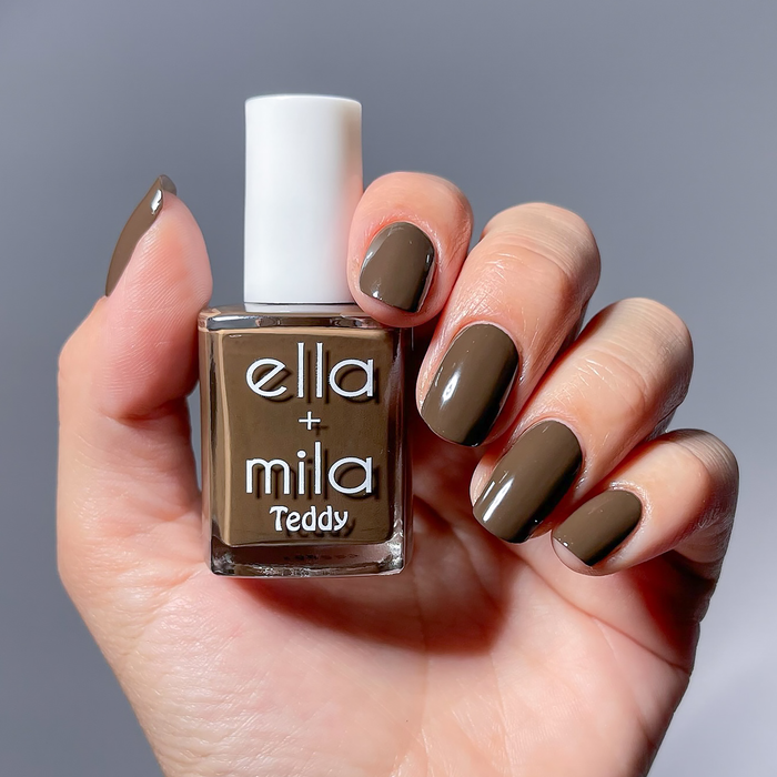 Bear with Me espresso brown nail polish manicure on a light skin tone, holding the bottle