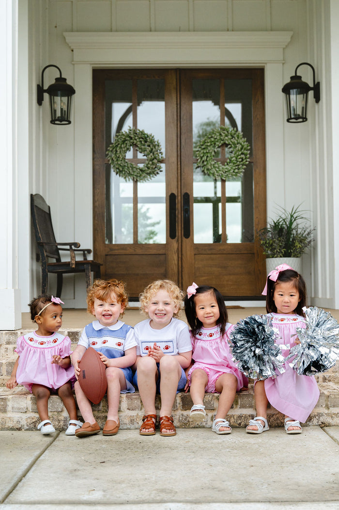 Smocked Football Jonjon in blue gingham with a hand-smocked panel of three footballs and a Peter Pan collar shirt