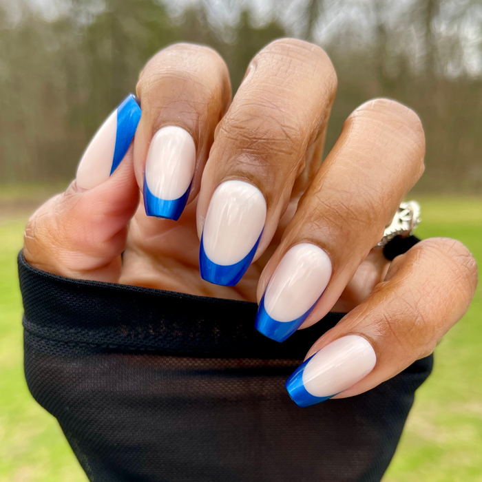 Blue Metallic French - Press-On | Medium | Coffin showing hand with shiny metallic blue french tip coffin press-on mani outdoors