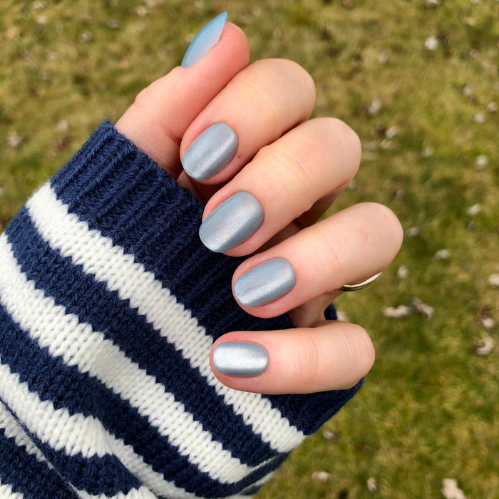 Blue Velvet - Press-On | Extra Short | Round showing hand with extra short round blue velvet press-on nails outdoors on grass background