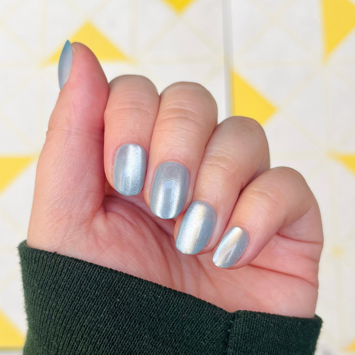 Blue Velvet - Press-On | Extra Short | Round showing hand with extra short round blue velvet press-on nails indoors on a patterned background