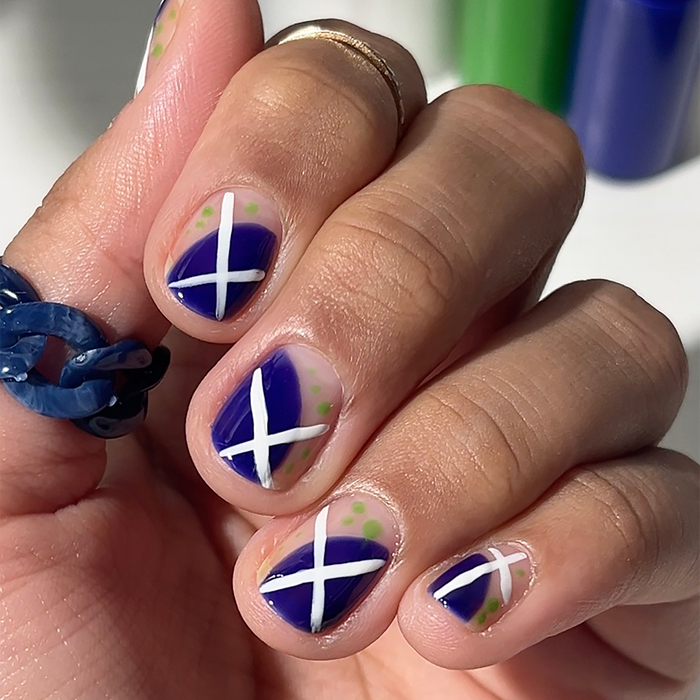 Bold Era Royal Blue liner used for blue and white X nail art, holding the bottles