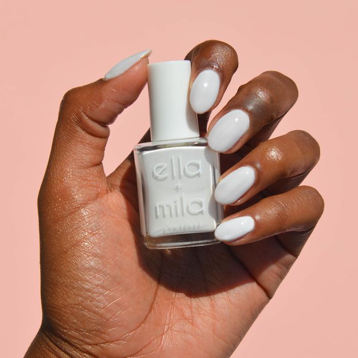 Boss milky white nail polish on a deep skin tone, hand holding the bottle