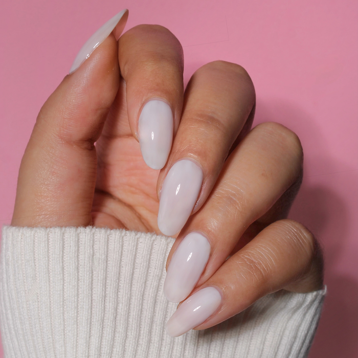 Boss glossy milky white nail polish manicure on a light skin tone with a white sweater