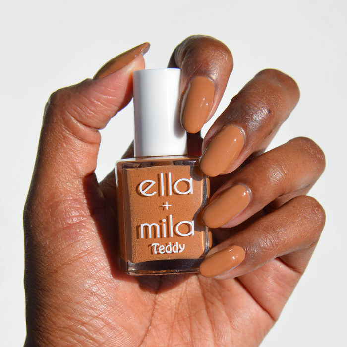Caramel Cub chestnut brown nail polish on a deep skin tone, hand holding the bottle