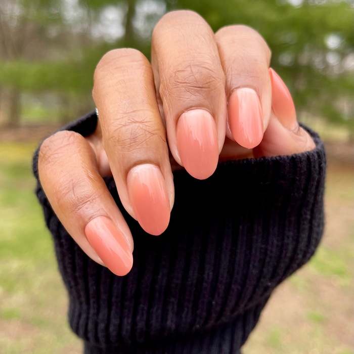 Caramel Syrup Gradient - Press-On | Medium | Oval showing hand with medium oval nails in warm caramel gradient manicure outdoors