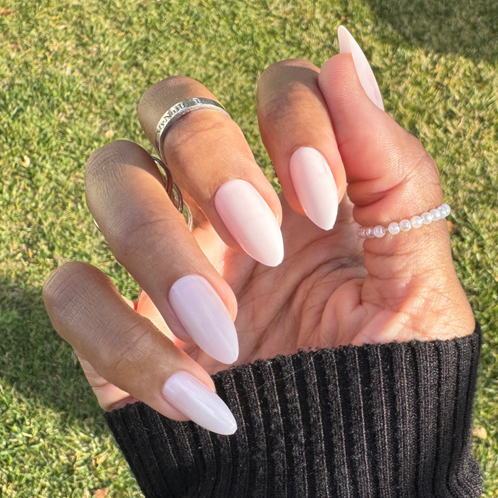 CCT Bridal Edition - Press-On | Long | Almond showcasing soft sheer pink long almond shaped false nails on hand with rings outdoors