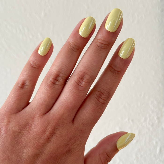 Citrus Chrome - Press-On | Short | Round showing hand with glossy bright yellow short round false nails manicure