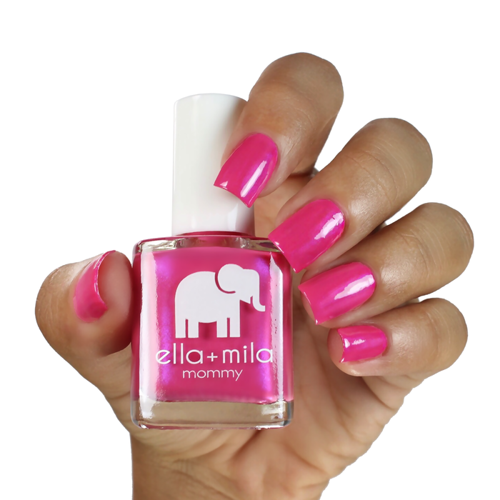 Cosmo Pink iridescent hot pink nail polish on a medium skin tone, hand holding the bottle