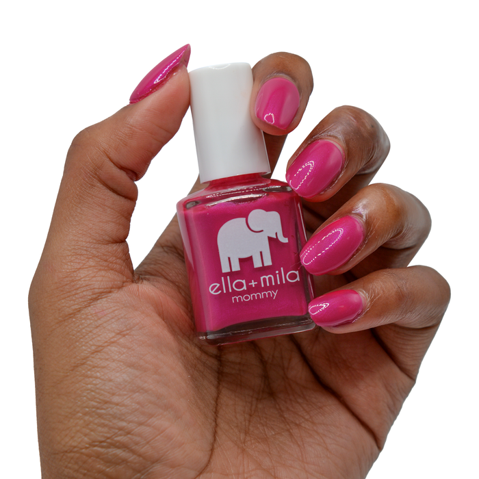 Cosmo Pink dark hot pink nail polish on a deep skin tone, hand holding the bottle