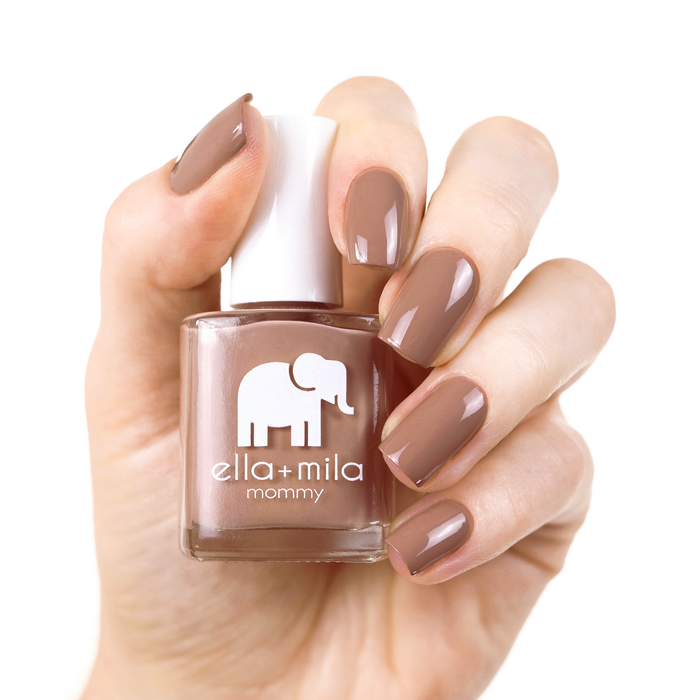 Cup O'Latte neutral brown nail polish on a light skin tone, hand holding the bottle