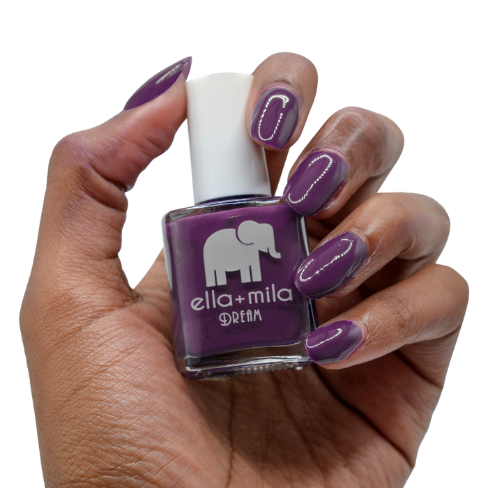 Date Night plum nail polish on a deep skin tone, hand holding the bottle