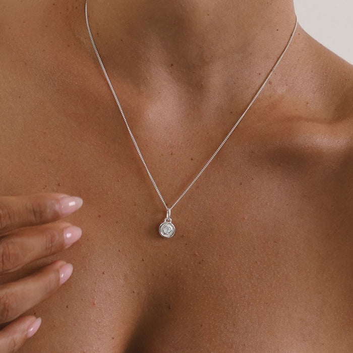 Silver necklace with a pendant on a person's neck