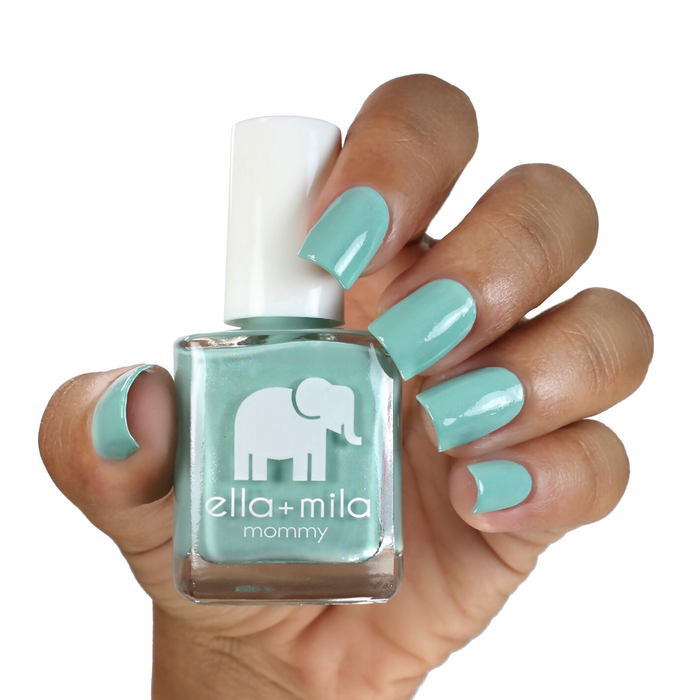 Don't Be Blue turquoise shimmer nail polish on a medium-deep skin tone, hand holding the bottle