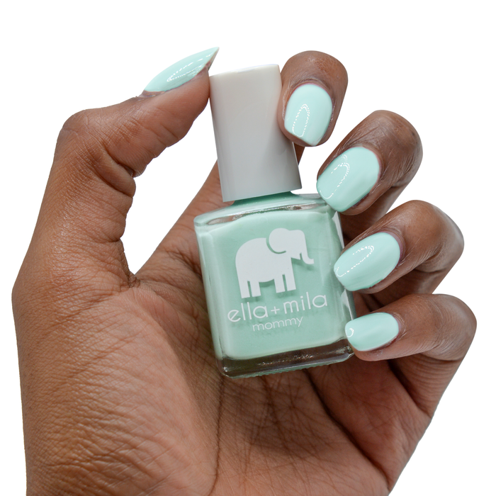 Don't Be Blue turquoise nail polish on a deep skin tone, hand holding the bottle