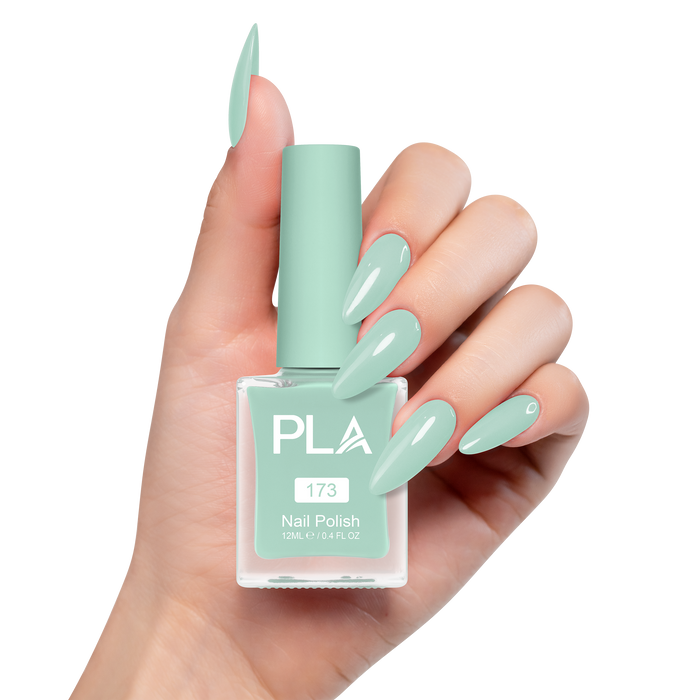 Hand with mint green nails holding a bottle of PLA nail polish