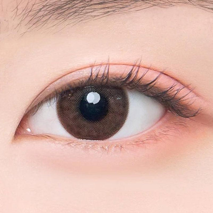 Macro shot of an eye wearing the DooNoon Epic 1-Day Grey (10pk) prescription colour contact lens, showing the multi-colored detail and natural effect on dark brown eyes.