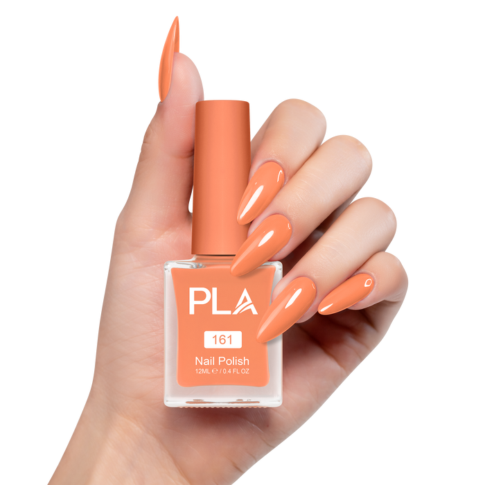 Hand holding a bottle of orange nail polish with matching nails on a white background
