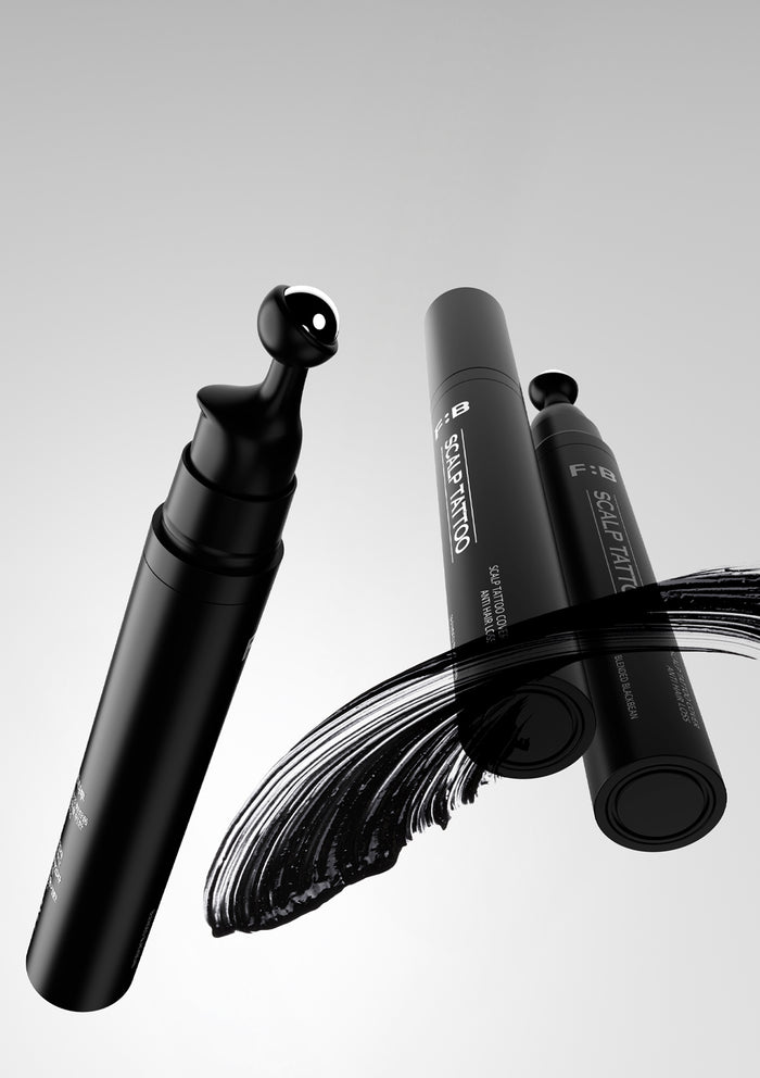 Black makeup brush with visible brand name on a gray background