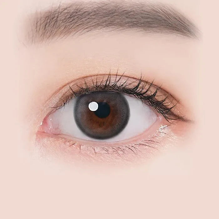 Macro shot of an eye wearing the i-Sha Ariel 1-Day Grey (10pk) prescription colour contact lens, showing the multi-colored detail and natural effect on dark brown eyes.
