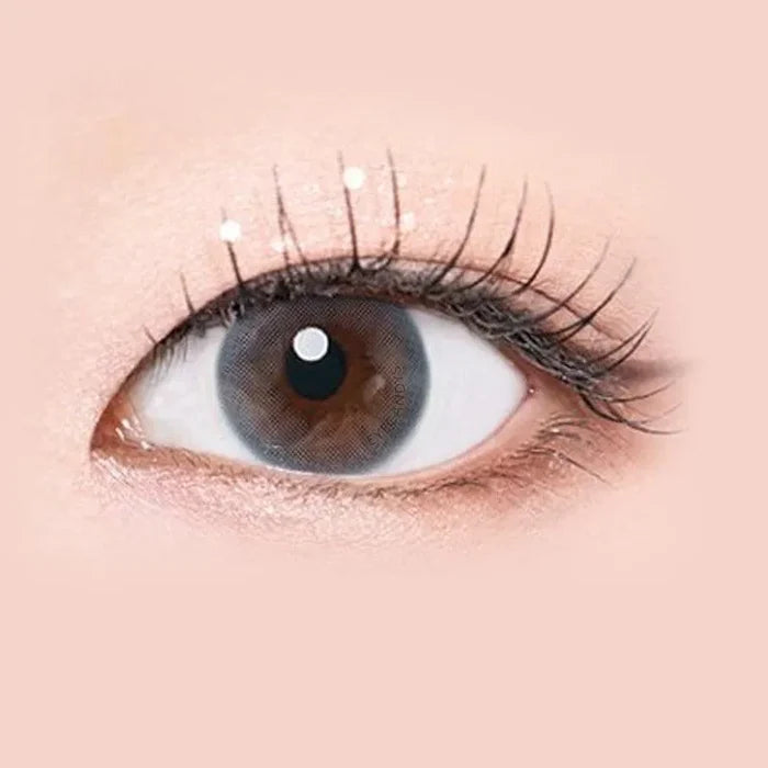 Macro shot of an eye wearing the i-Sha Serenity 1-Day Grey (10pk) prescription colour contact lens, showing the multi-colored detail and natural effect on dark brown eyes.