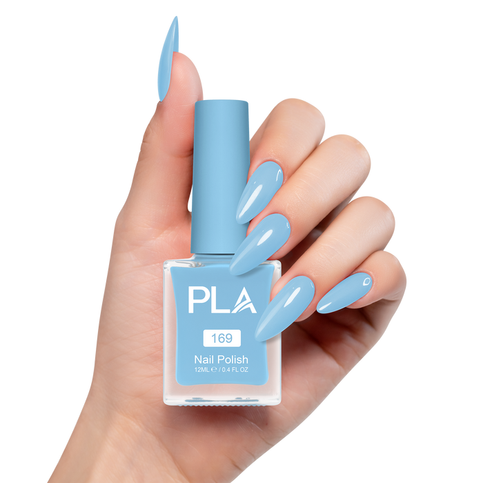 Hand holding a blue nail polish bottle with matching nails on a white background