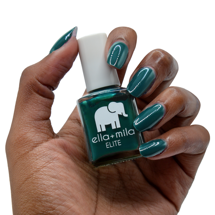 Island Hopping dark green nail polish on a deep skin tone, hand holding the bottle