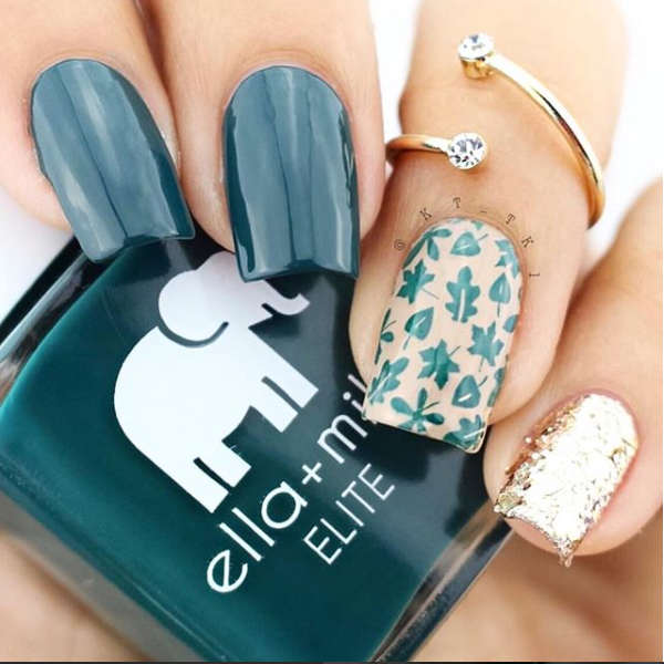 Island Hopping dark green nail polish with gold glitter and leaf-print accent nails