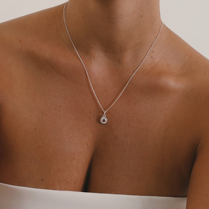 Silver necklace with a pendant on a mannequin with a neutral background