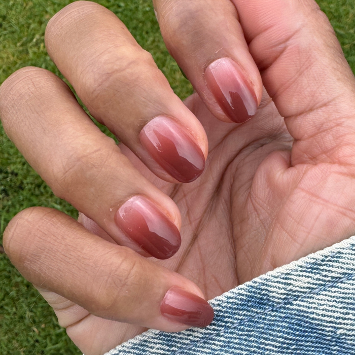 JJ Syrup Gradient - Press-On | Short | Round showing short round nails with cinnamon brown gradient mani on hand outdoors
