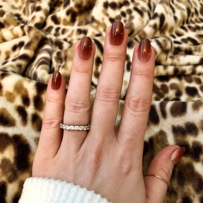 JJ Syrup Gradient - Press-On | Short | Round showing hand with short round nails in cinnamon brown gradient press-on manicure over leopard print background