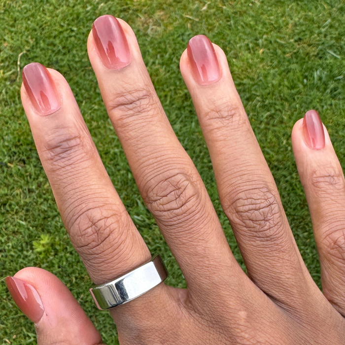 JJ Syrup Gradient - Press-On | Short | Round showing hand with short rounded false nails in cinnamon brown gradient manicure outdoors