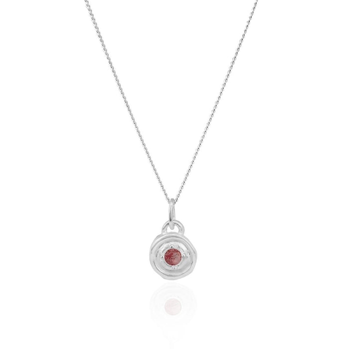 Silver necklace with a circular pendant featuring a red gemstone on a white background