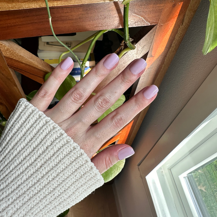 Lavender Stems - Press-On | Extra Short | Squoval showing hand with milky sheer lavender extra short squoval press-on nails in natural light