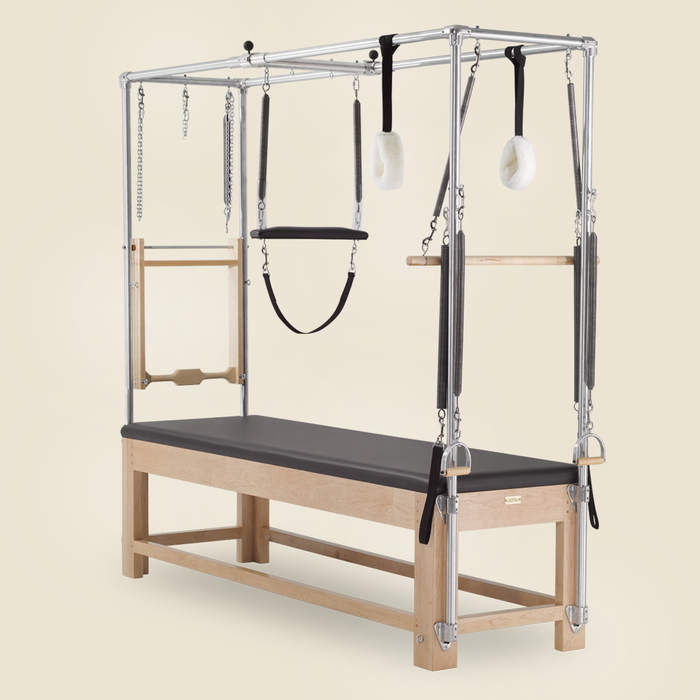 Gratz Pilates Cadillac fitted with leg springs, straps, and sheepskin loops on a maple frame.