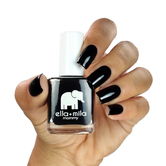 Lights Out black nail polish on a medium skin tone, hand holding the bottle